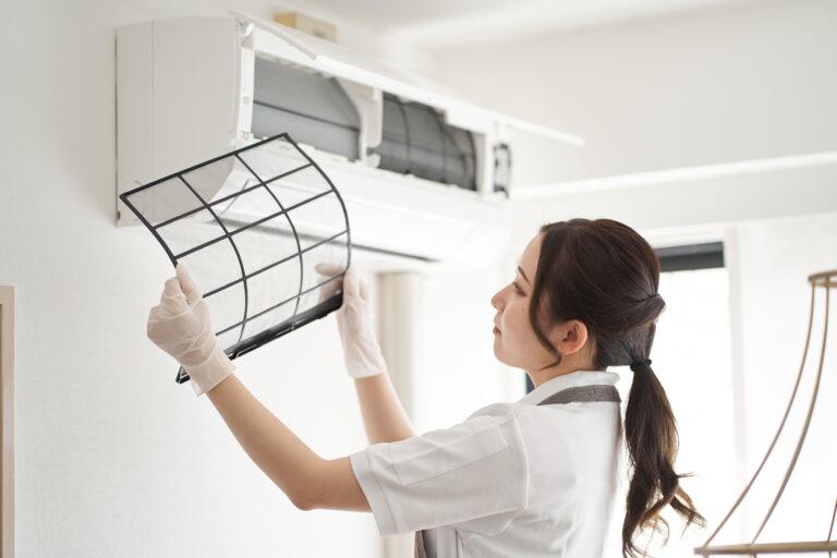 Asian woman cleaning air conditioner filter